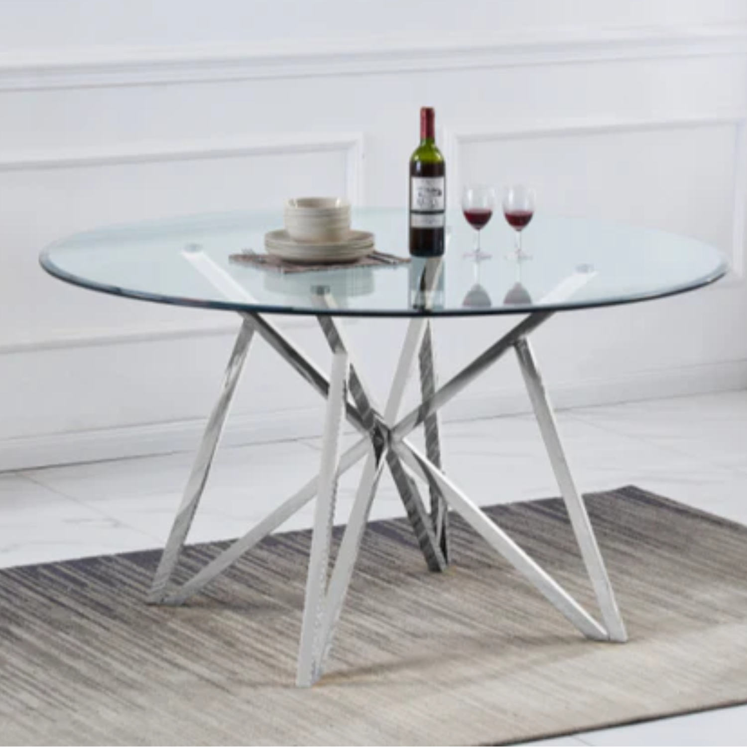 Table à manger avec plateau transparent et pieds en acier inoxydable.